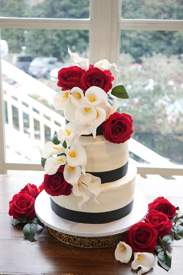 Cake by Callie's Cakes | Photo by Still Shots Photography An elegantly decorated three tier cake adorned with white Calla Lilies and fresh red roses.