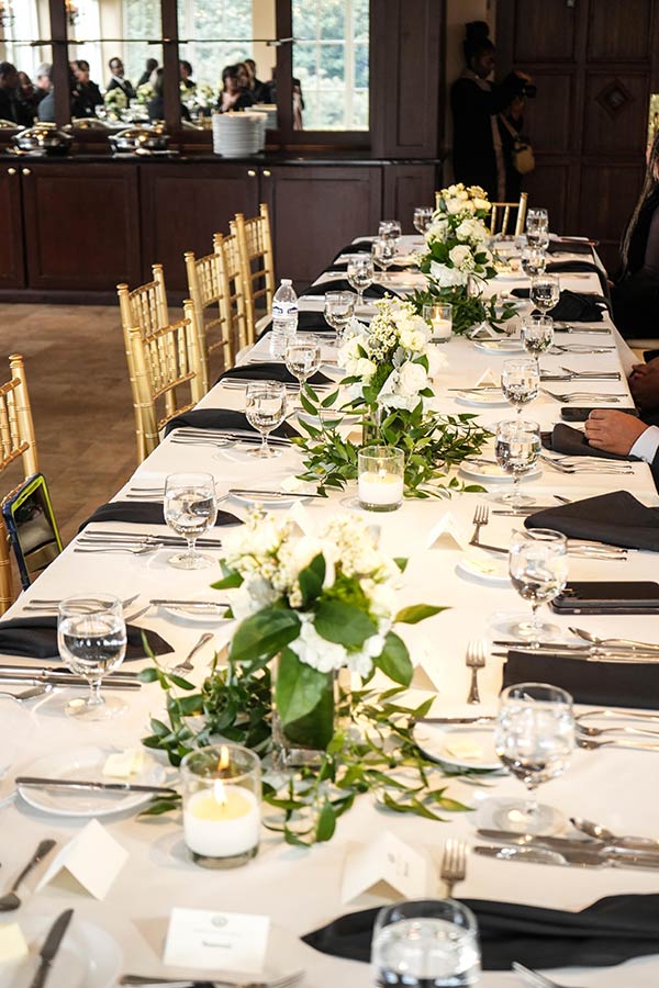 Tablescape | Still Shots Photography Two long banquet tables lined the Pavilion Room, elegantly decorated with white flowers and creating a natural aisle between them.